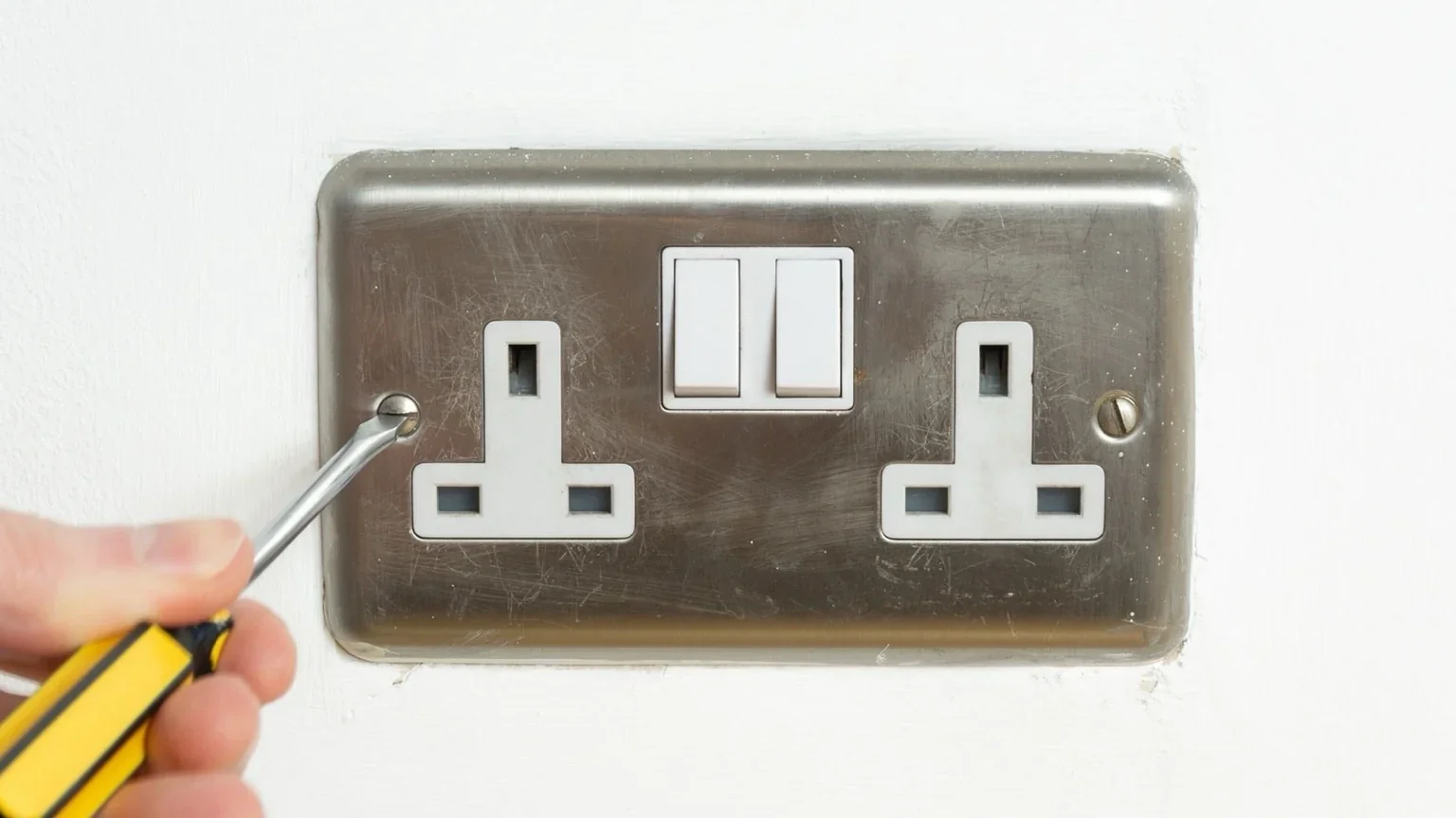 Close-up of Romford electrician fitting a wall socket — small domestic electrical works in Hornchurch